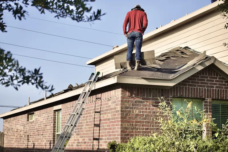 Professional roofer working on a residential roof in Point o'Woods